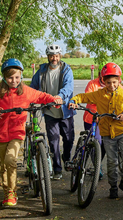 A group of children sitting on a blue surfboard during a fun birthday surfing lesson.