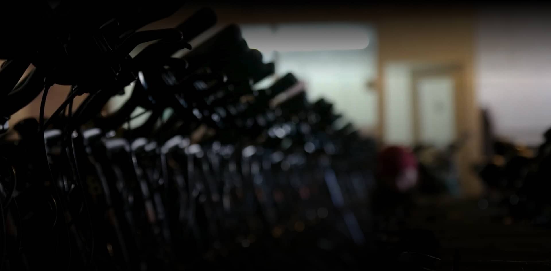 A row of rental bicycles lined up inside a bike hire shop, ready for customers to begin their Greenway cycling adventure.